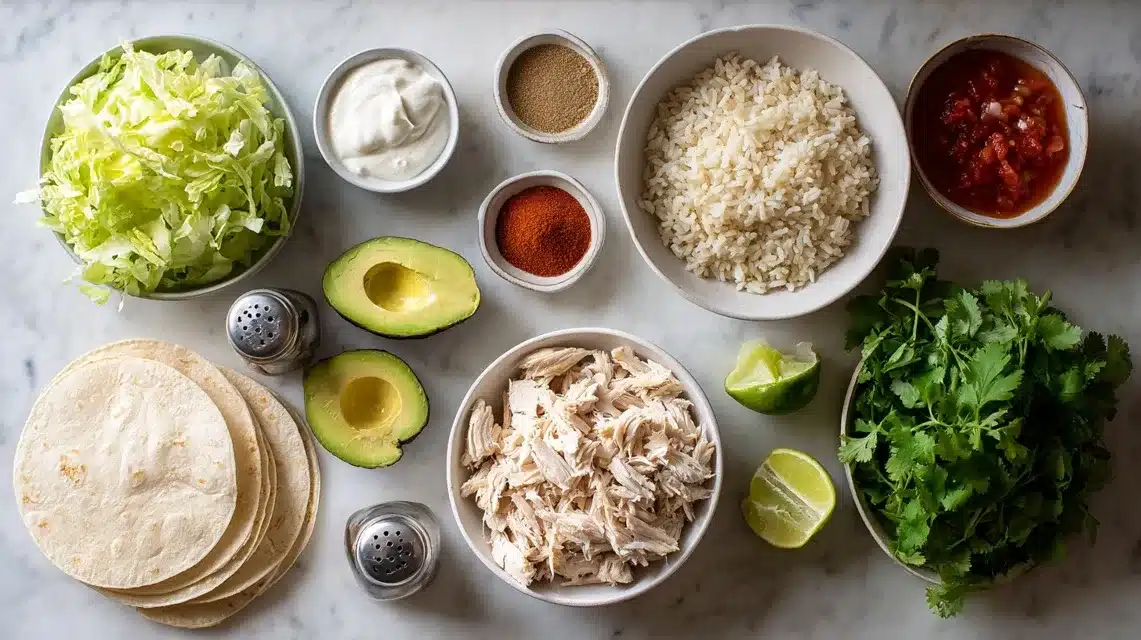 Ingredients for chicken and rice tacos on a marble surface