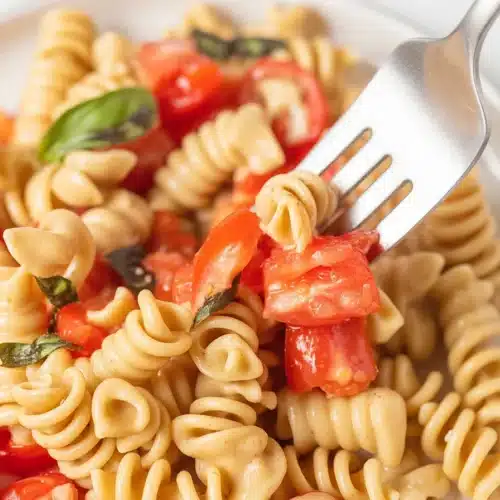 Fresh Tomato Pasta with garlic and basil, showcasing vibrant seasonal ingredients.